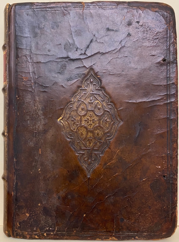 Cover of the 1608 Queen Elizabeth’s Prayer Book. The image shows the cover of the book, in dark-brown cracked leather, with a gilt-tooled geometrical design in the centre. The book is held at the Cushing Memorial Library and Archives.